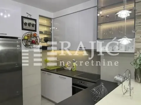 Modern kitchen with white cabinets and dark countertops. - image 7