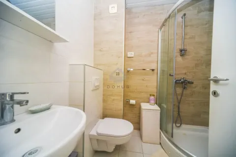 Bathroom equipped with a washbasin, toilet, and shower cabin. - image 10