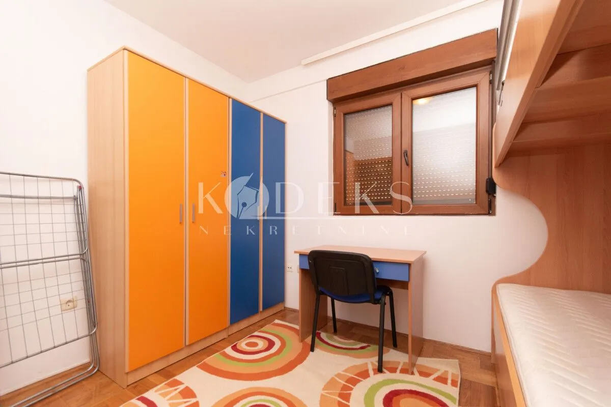 Children's bedroom with a wardrobe, desk, and bed.