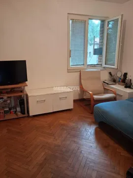 Spavaća soba sa krevetom, foteljom, televizorom i prozorom. - image 5