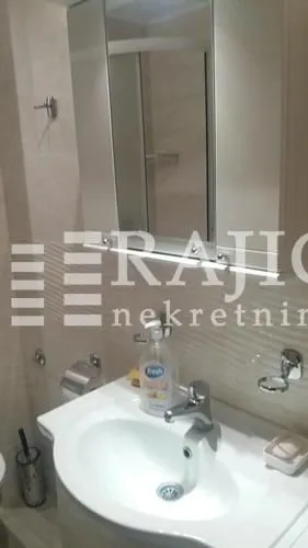 Pogled na umivaonik i ogledalo u kupatilu.