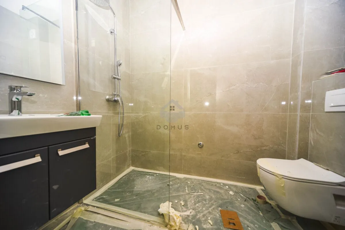 Novoopremljeno kupatilo sa tuš kabinom i ugradnom sanitarijom.