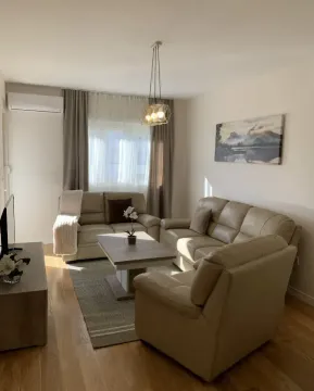 Svijetli dnevni boravak opremljen garniturom, stočićem i TV komodom. - image 2