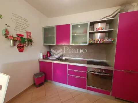 Small kitchen with bright pink cabinets and built-in appliances. - image 5