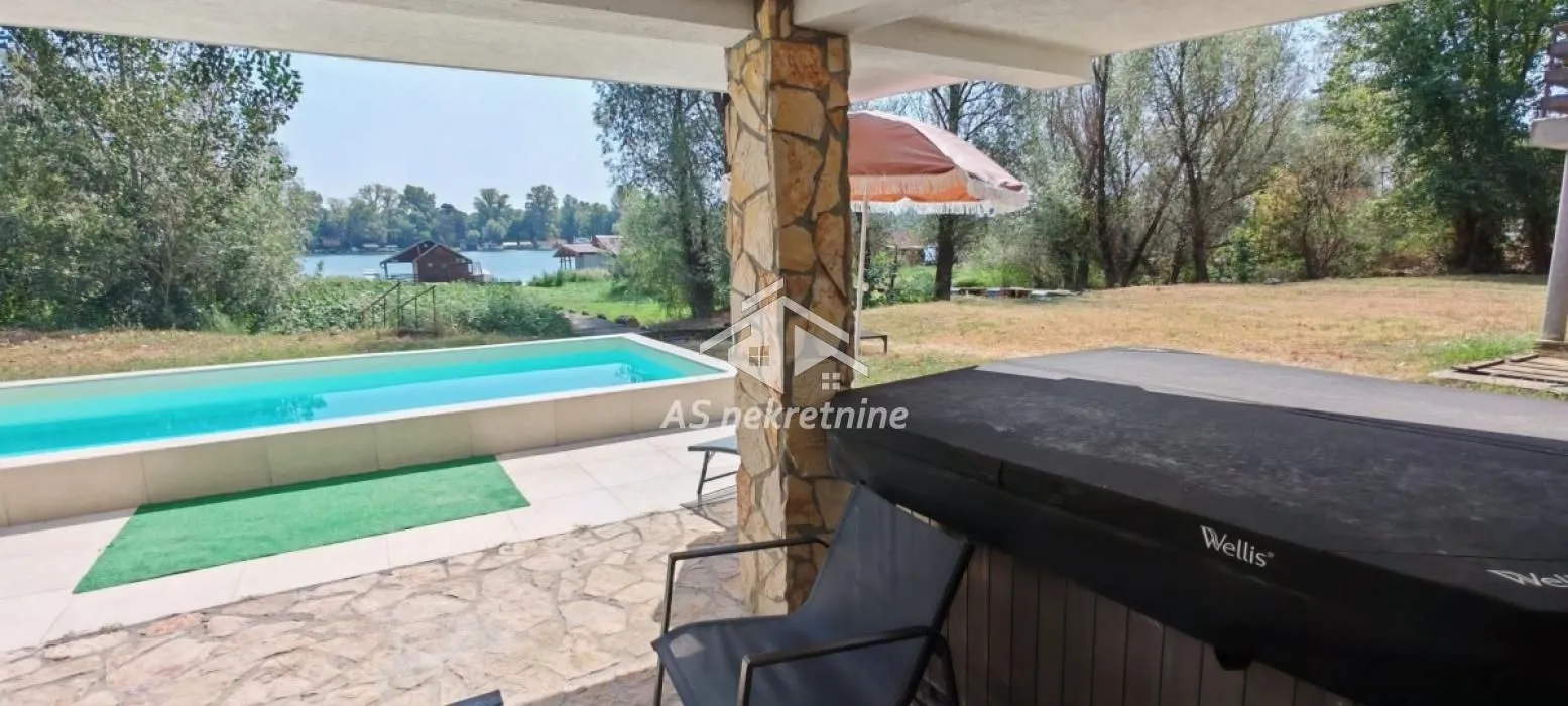 Covered terrace with a view of the swimming pool and lake.
