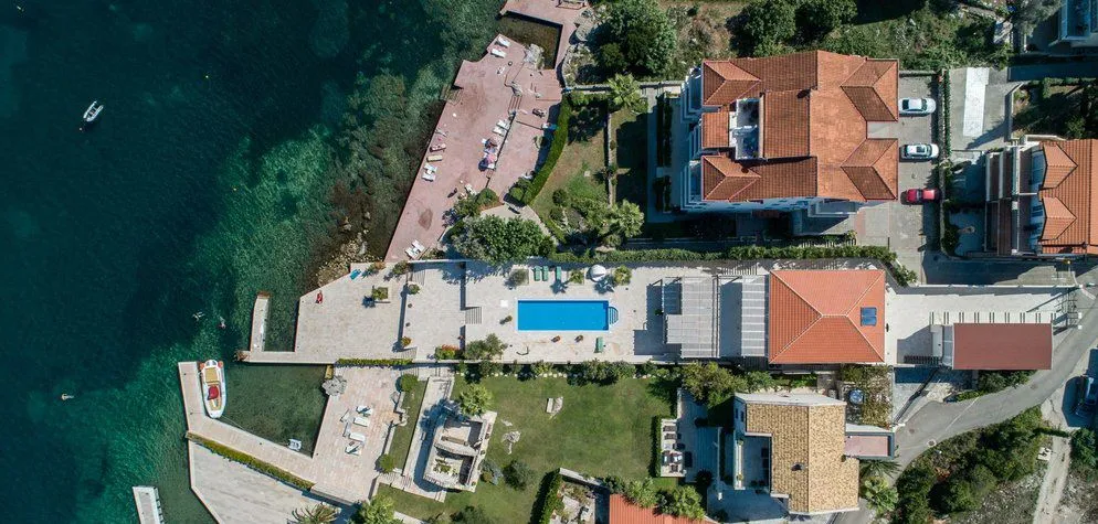 Pogled iz vazduha na vilu sa bazenom na samoj obali mora.