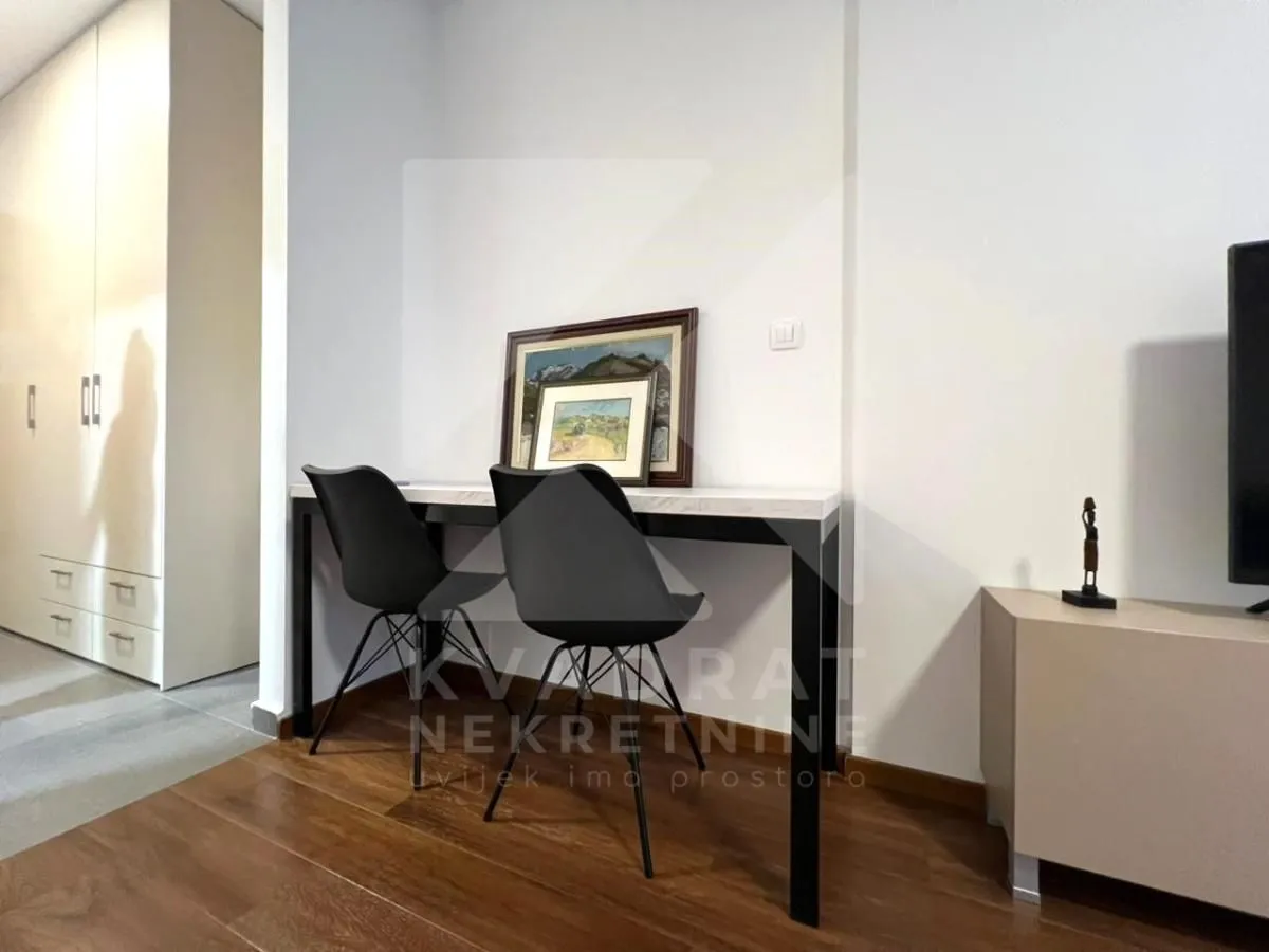 A desk with chairs against the wall in the living room.