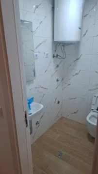 Manje kupatilo obloženo keramičkim pločicama sa tuš kabinom, umivaonikom i wc šoljom. - image 8