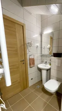 Manje kupatilo sa umivaonikom, wc šoljom i drvenim vratima. - image 8