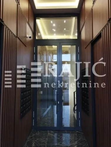 Building entrance with wooden wall paneling and glass doors.