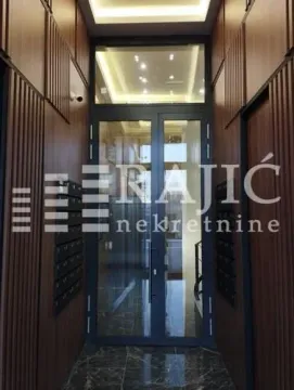 Building entrance with wooden wall paneling and glass doors. - image 15