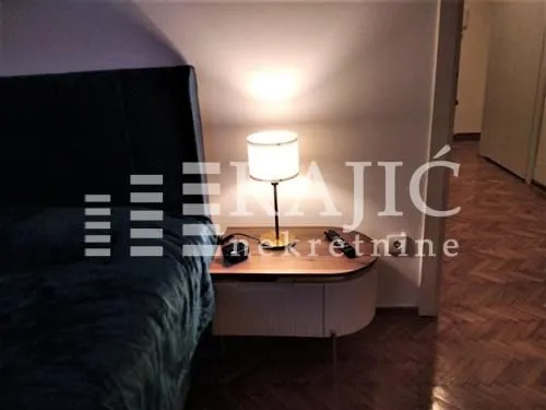 Bedroom with a bed and a bedside table with a lamp.