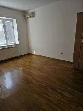 Svijetla prazna soba sa parketom, klima uređajem i ormarom. - image 10