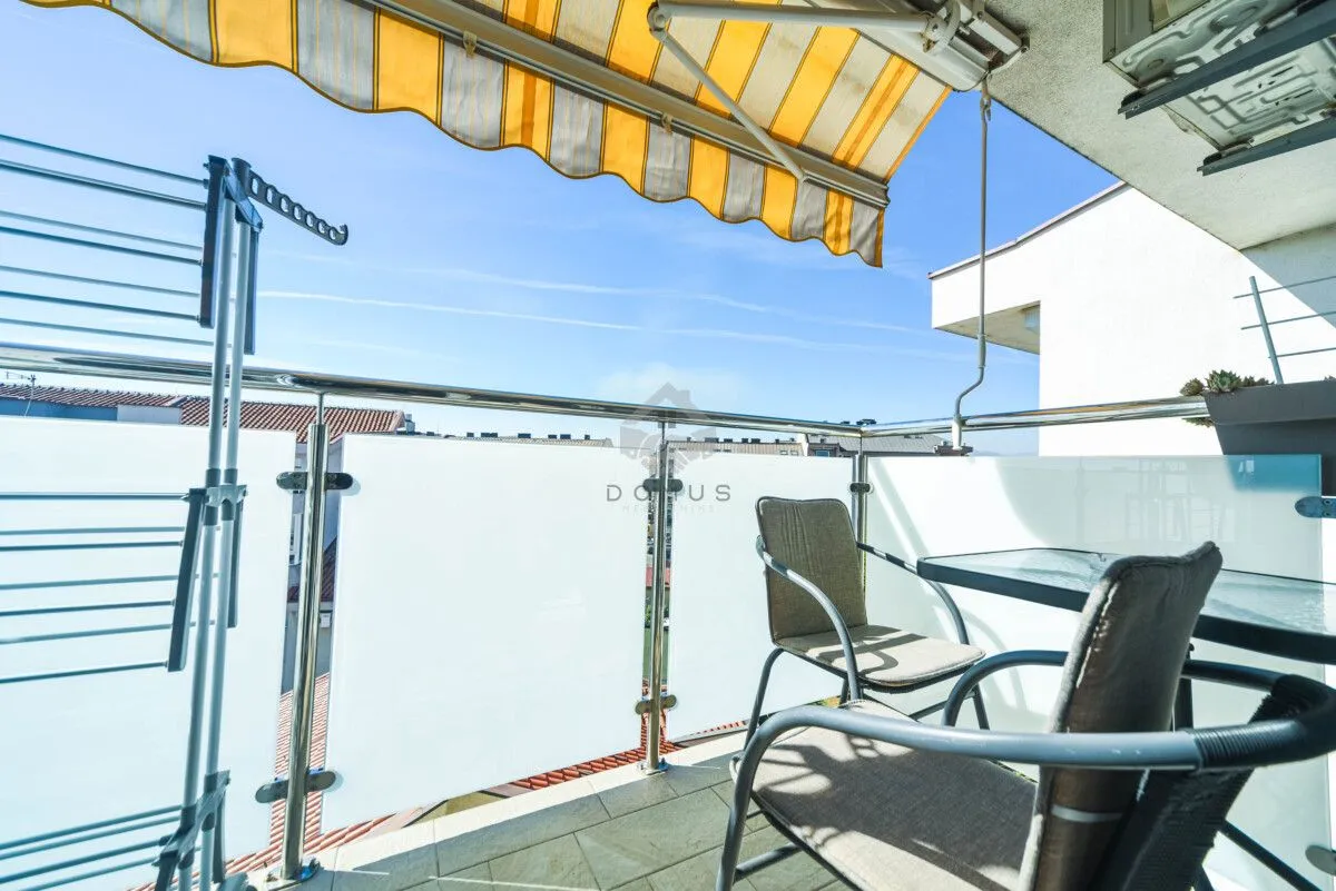 Namješten balkon sa garniturom za sjedenje i tendom.