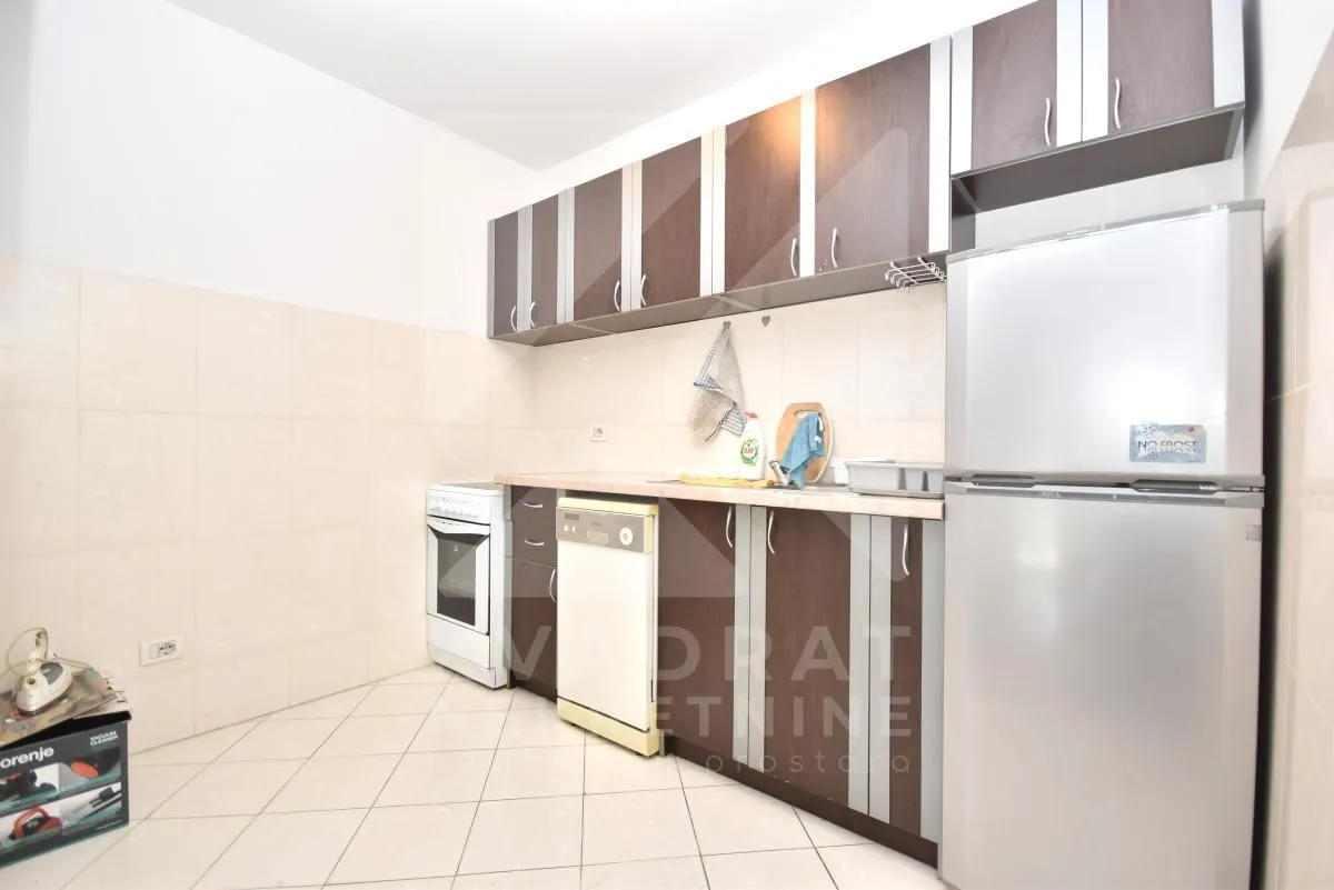Kitchen equipped with wooden cabinets, a stove, and a refrigerator.