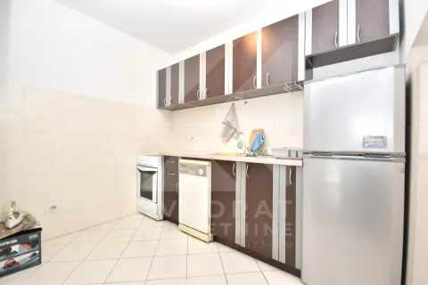 Kitchen equipped with wooden cabinets, a stove, and a refrigerator. - image 4