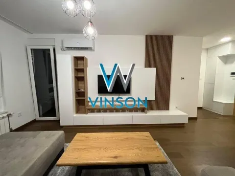 Dnevna soba opremljena nameštajem i televizorom. - image 3