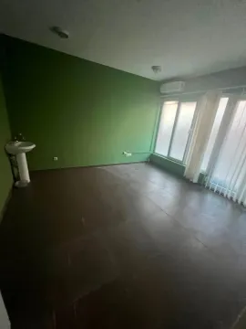 Empty room with a green wall, floor tiles, and a washbasin. - image 5