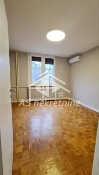 Prazna soba sa parketom na podu i klima uređajem na zidu. - image 6