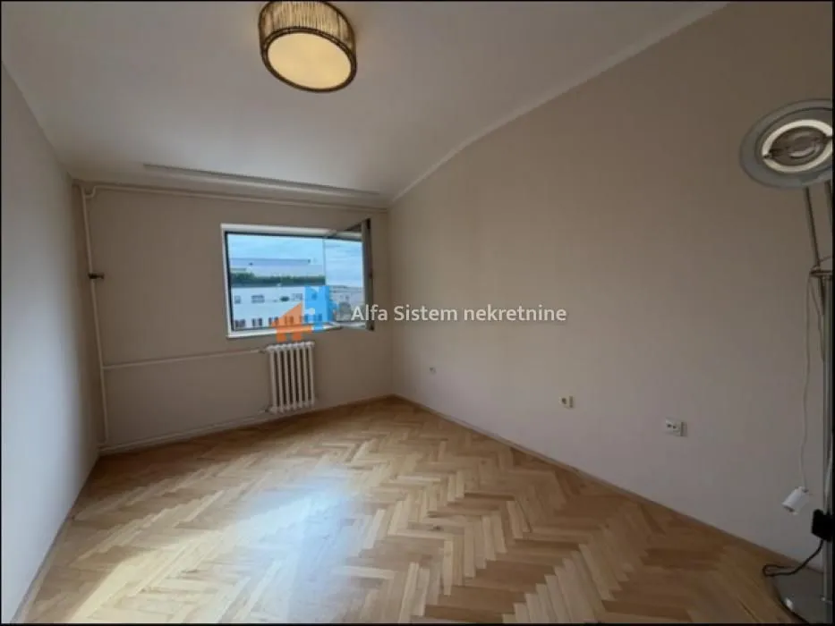 Empty room with parquet flooring and a window.