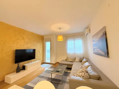 Living room with a sectional sofa, TV, and access to the terrace. - image 2