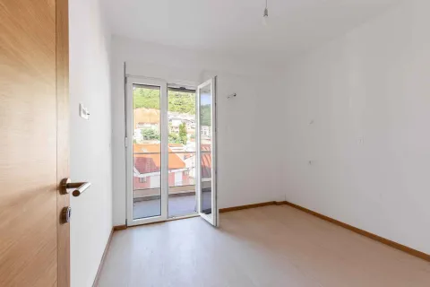 Prazna svijetla prostorija sa balkonskim vratima i pogledom na naselje. - image 14