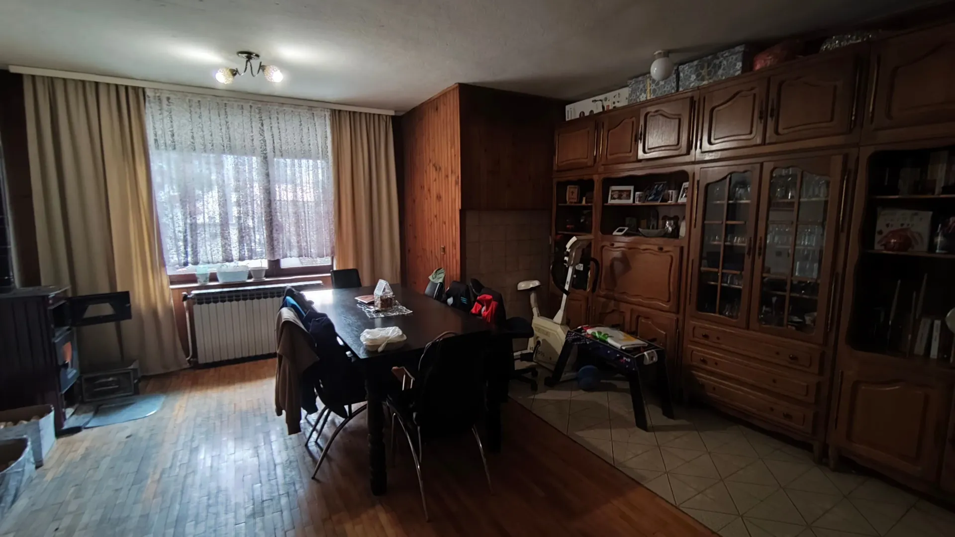 Dnevna soba sa trpezarijom i velikim drvenim ormarom.
