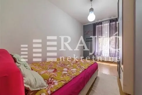 Bedroom with a double bed and a window with curtains.