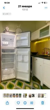 Kuhinja sa otvorenim frižiderom i bijelim elementima. - image 7