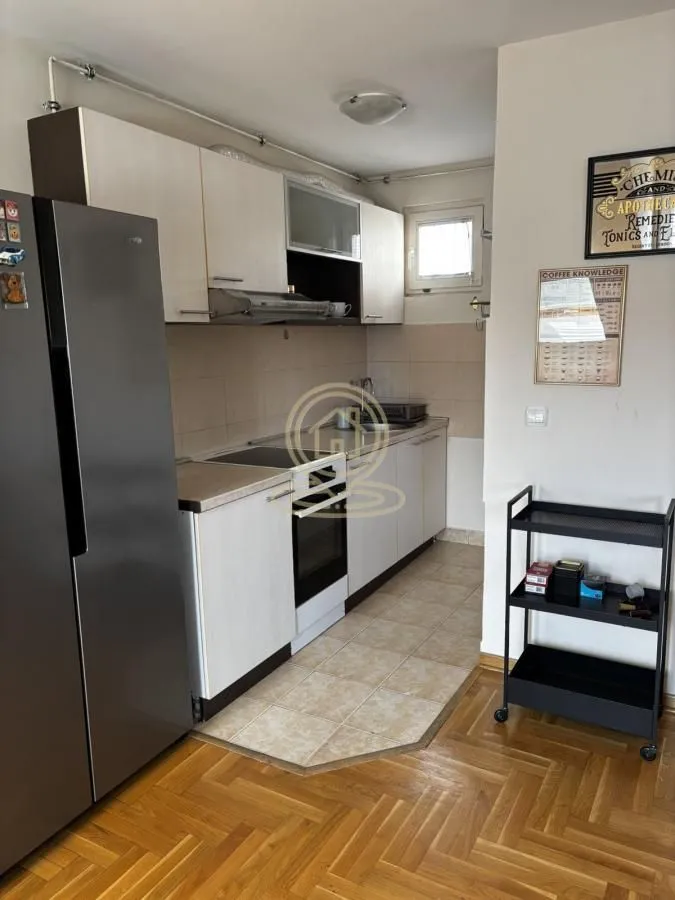 Smaller equipped kitchen with white cabinetry and a refrigerator.