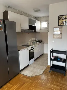 Smaller equipped kitchen with white cabinetry and a refrigerator. - image 3