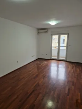 An empty room with wooden parquet flooring, an air conditioner, and balcony access. - image 5