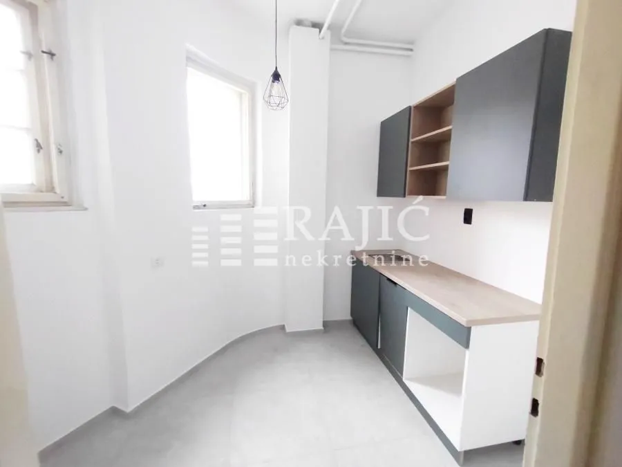Empty kitchen with lower and upper cabinets.