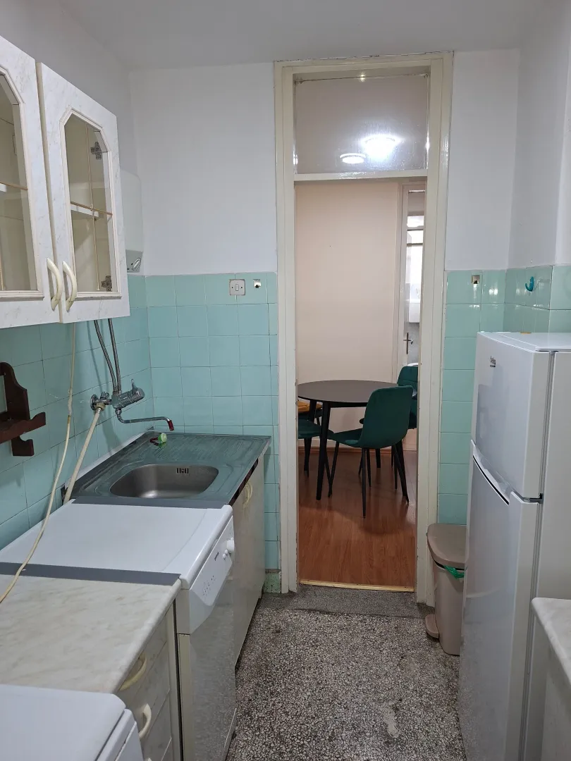 Small kitchen with a sink, refrigerator, and cabinetry.