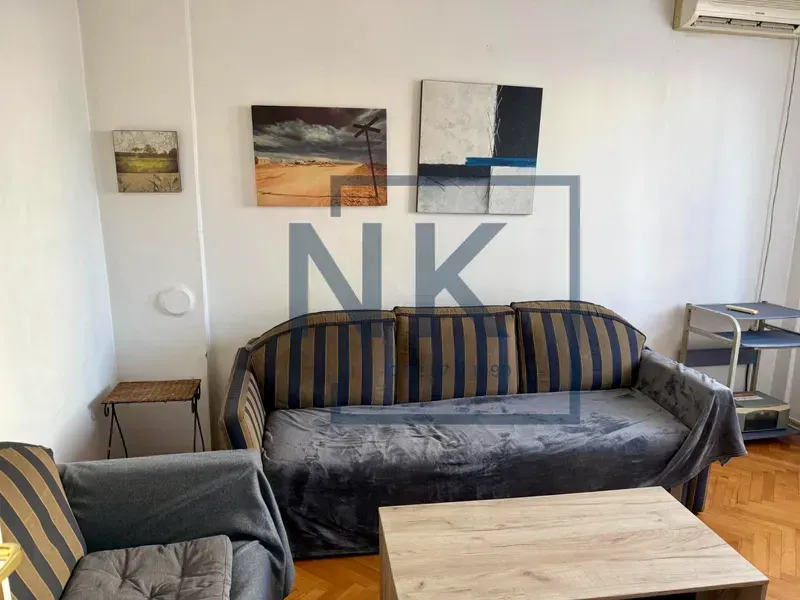 Living room with a sofa and paintings on the wall.