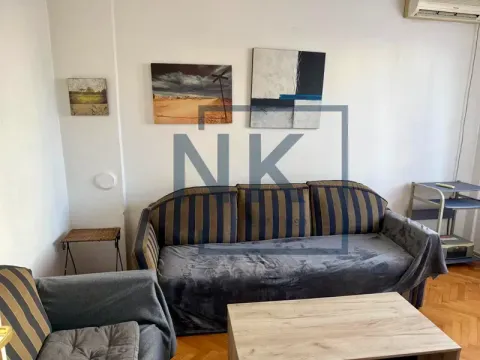 Living room with a sofa and paintings on the wall. - image 2