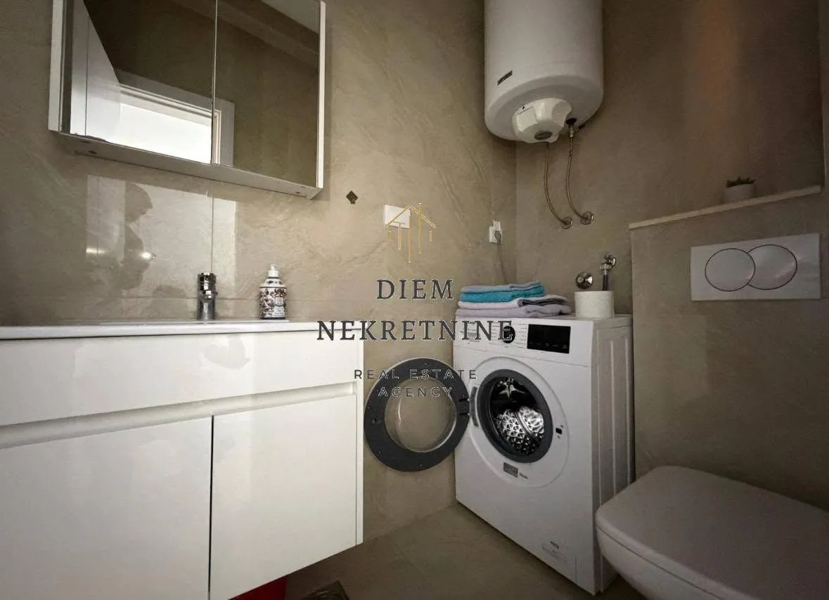 A modernly equipped bathroom with a washing machine and water heater.