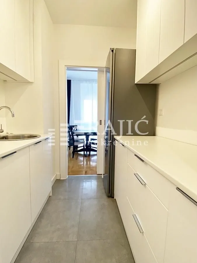 Modern kitchen with white cabinetry and a refrigerator.