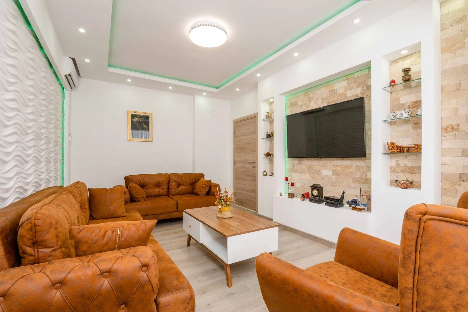 Spacious living room with sofa set, coffee table and TV.