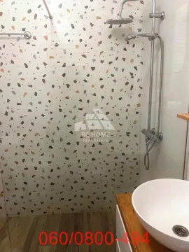Moderna tuš-kabina sa šarenim pločicama i umivaonik u kupatilu. - image 11
