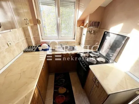 Small kitchen with wooden cabinets and a window. - image 2