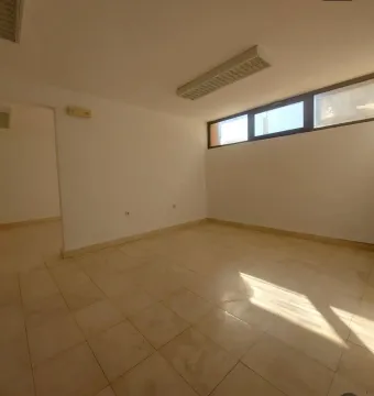 Empty bright room with tiled floors and high-level windows. - image 16
