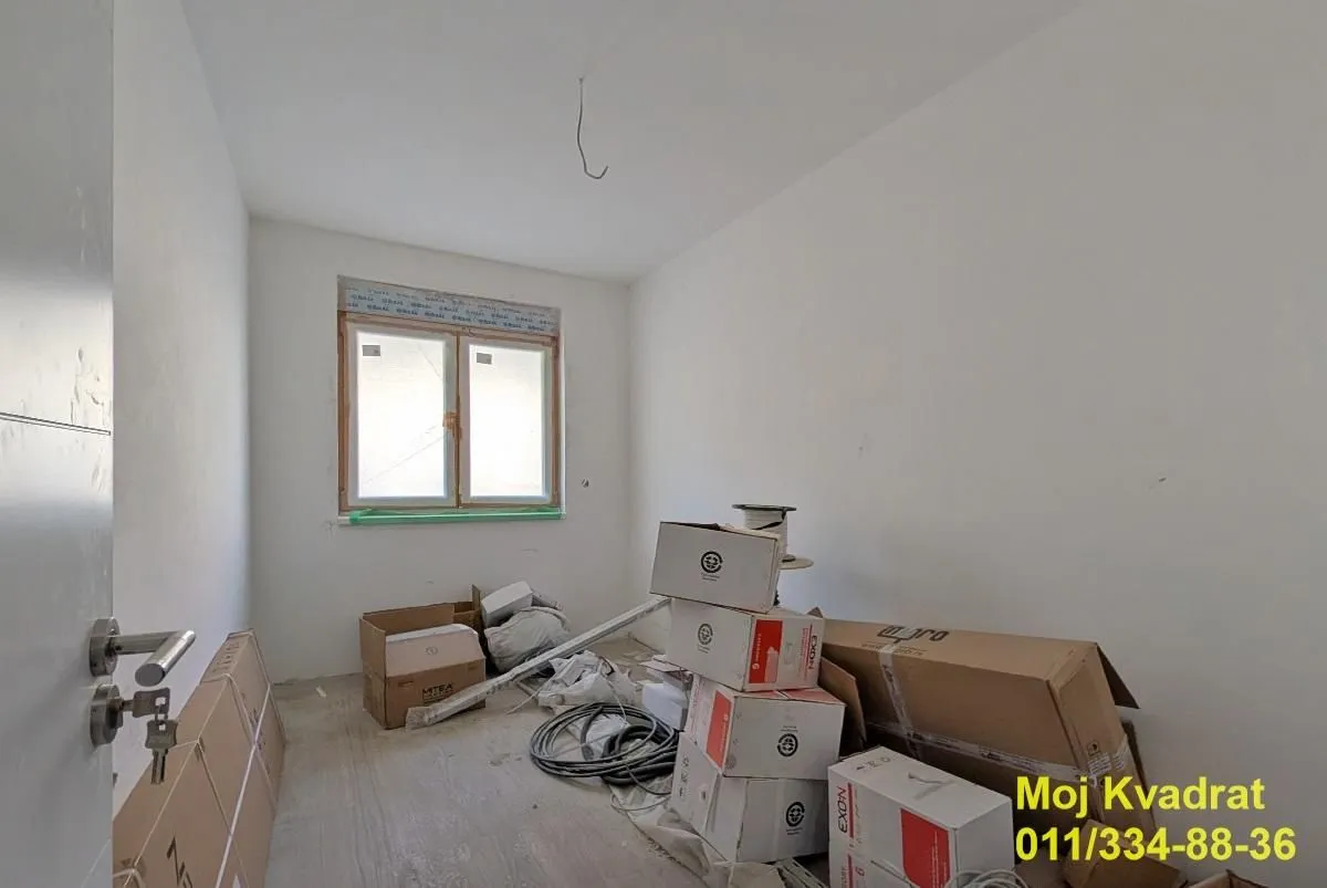 Prazna prostorija sa građevinskim materijalom i kutijama.