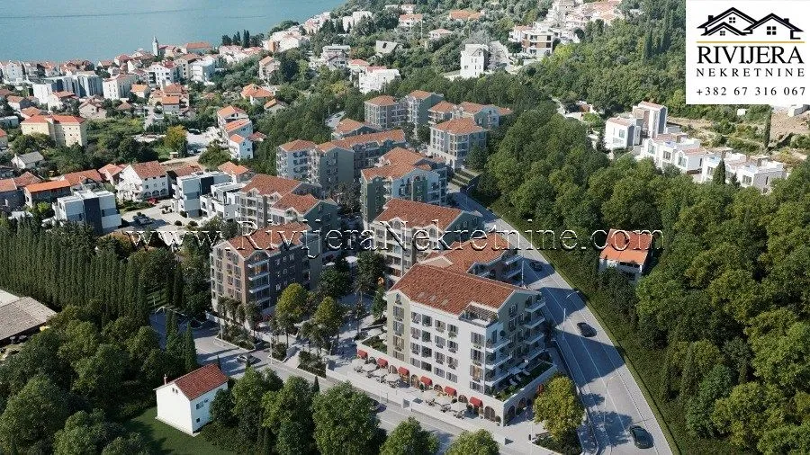 Pogled iz vazduha na kompleks zgrada i okolno naselje blizu mora.