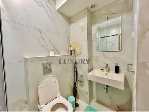 Moderne opremljeno kupatilo sa svijetlim mermernim pločicama, umivaonikom i WC šoljom. - image 4