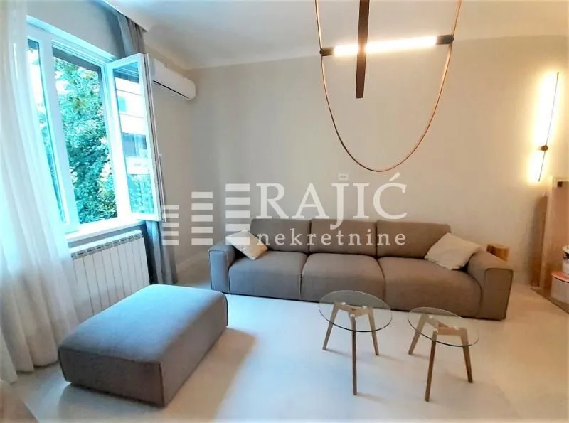 Living room with sofa, coffee tables, and a window.
