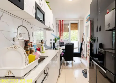 View of the kitchen with white cabinetry and a dining area in the background. - image 3