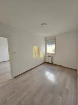 Prazna soba sa svetlim parketom i prozorom. - image 13