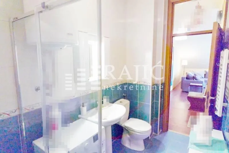 Bathroom with a shower cabin, washbasin, and toilet.