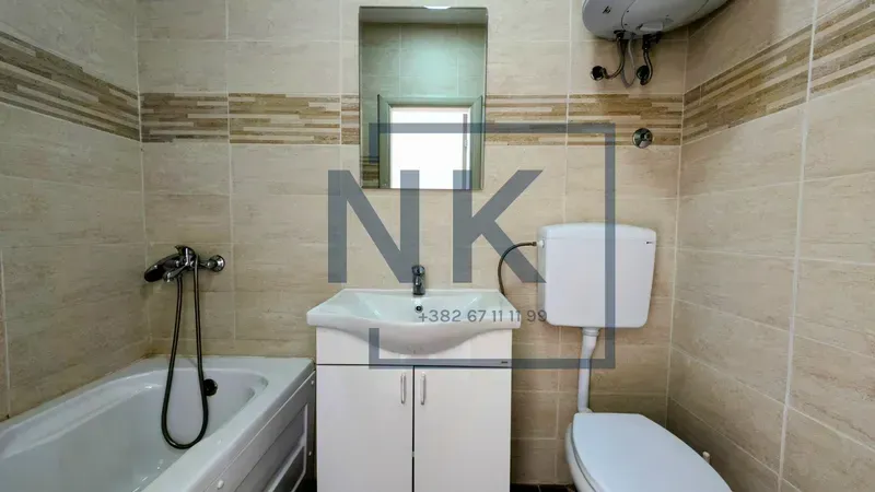 Bathroom equipped with a bathtub, a vanity with a sink, and a toilet.